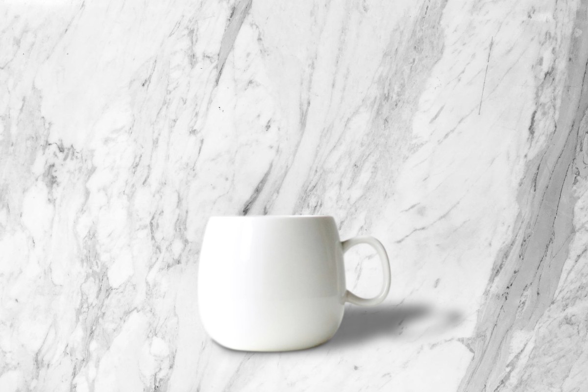Ceramic mug placed on a marble scene with a soft shadow
